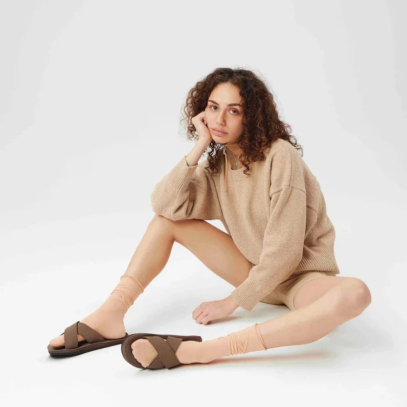 A woman wearing brown indosole sandals